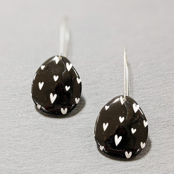 Boucles d'oreilles suspendues coeurs blancs fond noir